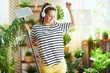 © Alliance - smiling woman in striped shirt in sunny day doing housework