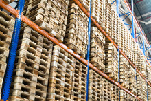 Huge Distribution Warehouse With Wooden Pallets On High Shelves