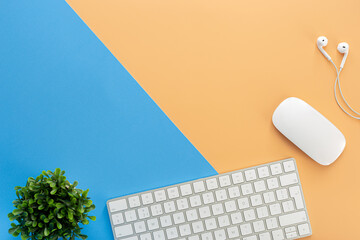 Wall Mural - Top view white keyboard and mouse  isolated on a blue and orange background 