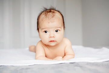 Closeup of cute adorable sleeping Asian Chinese mixed race newborn baby boy. Adorable infant kid child lying on bed in bedroom and dreaming napping. Healthy happy childhood. Ethnic diversity