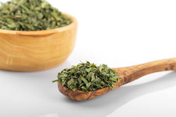 Wall Mural - Dried parsley. Dried parsley in wooden bowl, on white background. Parsley.