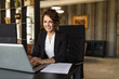 © bnenin - Smiling woman using laptop at work, portrait.