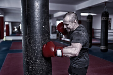 Wall Mural - Boxer training  hitting the heavy bag