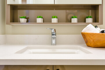 Fragment of luxury bathroom with a sink and wooden cabinet