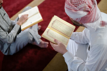 Wall Mural - two muslim people in mosque reading quran together concept of islamic education