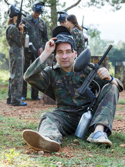 Sticker - Portrait of confident man paintball player with marker gun ready for game outdoors