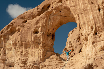 Female hiker posing at the Great Arch in the Timna national park, southern Israel. Famous tourist attraction in the national park. Vacation in Israel. 