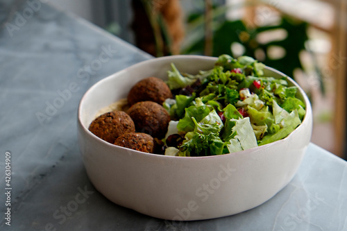 Obraz Dibond Vegan bowl with chickpea falafel balls and salad. Clean eating concept. Cruelty free fast food restaurant table with plate full of food. Close up, copy space, background.