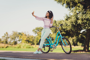 Sticker - Full body photo of brunette dark skin happy woman make selfie in park bike make v-sign in countryside outside outdoors