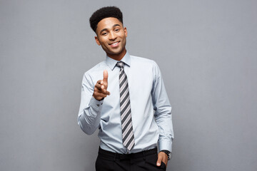 Wall Mural - Business Concept - Cheerful happy young African American holding gun sign with fingers pointing to other.