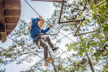 Happy Child In A Helmet, Healthy Teenager School Boy Enjoying Activity In A Climbing Adventure Park On A Summer Day