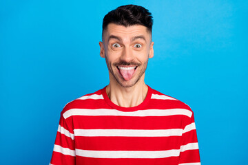 Sticker - Photo of funky funny happy young guy make silly face tongue out isolated on pastel blue color background