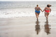 © DisobeyArt - Plus size friends walking together on the beach having fun during summer vacation - Focus on women back