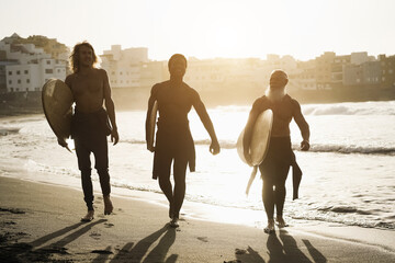 Wall Mural - Multi generational surfer friends having fun on the beach after surf session - Main focus on faces