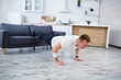 © DSMT - A young man goes in for sports at home, he does push-ups on the couch. Healthy lifestyle