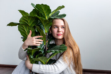 Gardening home. Blonde woman holding plant. Closeup portrait of beautiful woman