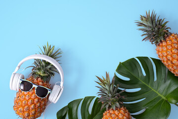 Sticker - Funny pineapple wearing white headphone isolated on blue background.