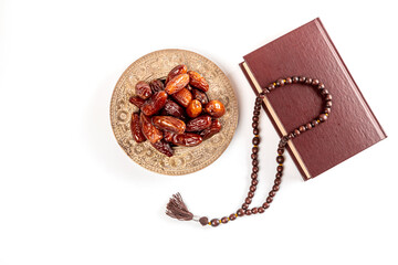 Wall Mural - Muslim holiday of the holy month of Ramadan Kareem. Beautiful background with religious book Quran and dried dates on a tray, Top view