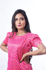 Young Indian girl posing in a studio for a model shoot wearing a pink coloured  traditional and ethnic dress called sharara