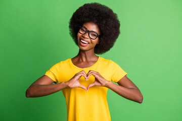 Poster - Photo portrait of cheerful girl showing heart sign fingers wearing glasses isolated on bright green color background