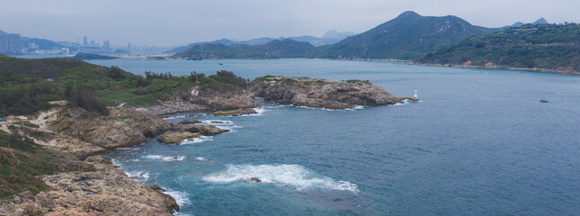 Poster - Mesmerizing view of beautiful rocky coastline with mountains in the background