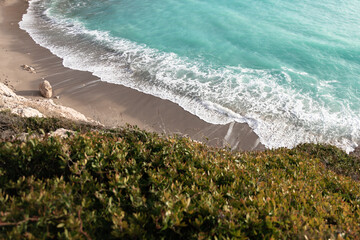 Beach and rocky coast with turquoise color sea in Sitges, Spain