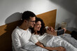 © Zoran Zeremski - Smiling couple in the morning laying in bed in the bedroom making selfie.