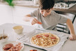 © Olga Krivokoneva - Little kid boy making pizza sitting at the table on the kitchen. Children helping in cooking lifestyle image