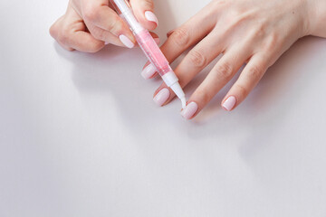 Wall Mural - Female hands with pastel trendy manicure moisturizing cuticle.