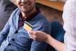 Cropped view of credit card in hand of woman near smiling husband on burred background
