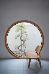 Wall Mural - Minimalism interior of wooden chair with round window and tree