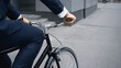 © LIGHTFIELD STUDIOS - cropped view of businessman in suit riding bicycle near building.