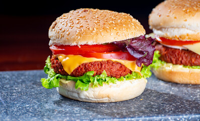 Wall Mural - Tasty vegetarian food, homemade cheeseburgers made from plant based soya meat with cheese, onion, green lettuce and tomatoes