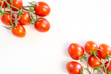 Branch of fresh cherry tomatoes isolated on white background with copy text in middle