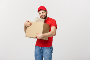 Wall Mural - Portrait delivery man in cap with red t-shirt working as courier or dealer holding two empty cardboard boxes. Receiving package. Copy space for advertisement