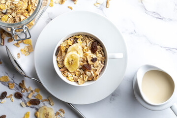 Milk bowl with whole grain breakfast cereals and jug of milk. Muesli with dried fruits and dried fruits. With copy space. On light background.