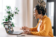 Online business group brainstorm by video conference. Satisfied african american young woman, communicates with business partners by video call uses laptop, multiracial colleagues on a laptop screen