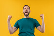 © wpadington - Studio portrait of joyful, excited, glad bearded man with wide open mouth and clenched fists celebrating money win in online lottery or at bookmaker's, isolated over yellow background