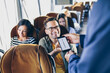 © hedgehog94 - Young male traveler showing  e-ticket on mobile phone screen to a bus driver.
