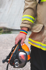 Poster - firefighter holding helmet, with LGBT bracelet. Vertical photo