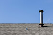 Shingled Roof with Metal Chimney under a Blue Sky