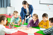 © JackF - Young female teacher and happy schoolkids playing interesting board game during lesson in classroom