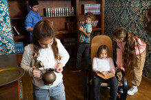 Interested Tween Girl Examining Ancient Kettle In Quest Room Stylized As Old Library
