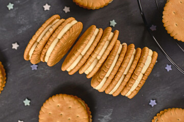 Wall Mural - Cream filled sandwich cookies on dark background