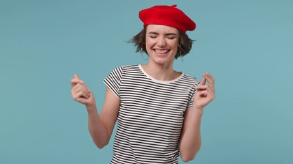 Wall Mural - Young woman 20s wear red french beret hat striped t-shirt dance clench fists waving rise expressive gesticulating hands fool around have fun enjoy play isolated on pastel blue color background studio