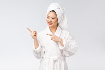 Beauty portrait of young woman showing and pointing finger to empty copy space, asian beauty in bathrobe.