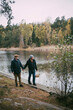 © Maskot - Homosexual couple holding hands while walking at riverbank