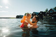 © Maskot - Side view of cheerful daughter with father in lake during vacations