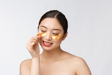 asian beauty teenager woman care her skin with gold eye masks patches under eyes