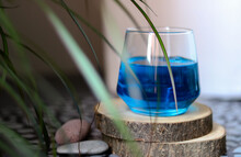 Blue Curacao Liquor On A Wooden Platform Behind Palm Leaves
